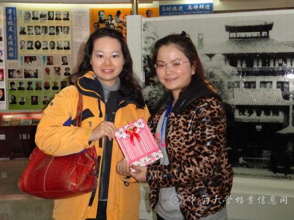 香港大学牙学院领队获得湘雅医学院学生院史讲解团赠送的纪念品后与团员张妍合影(学生院史讲解团)